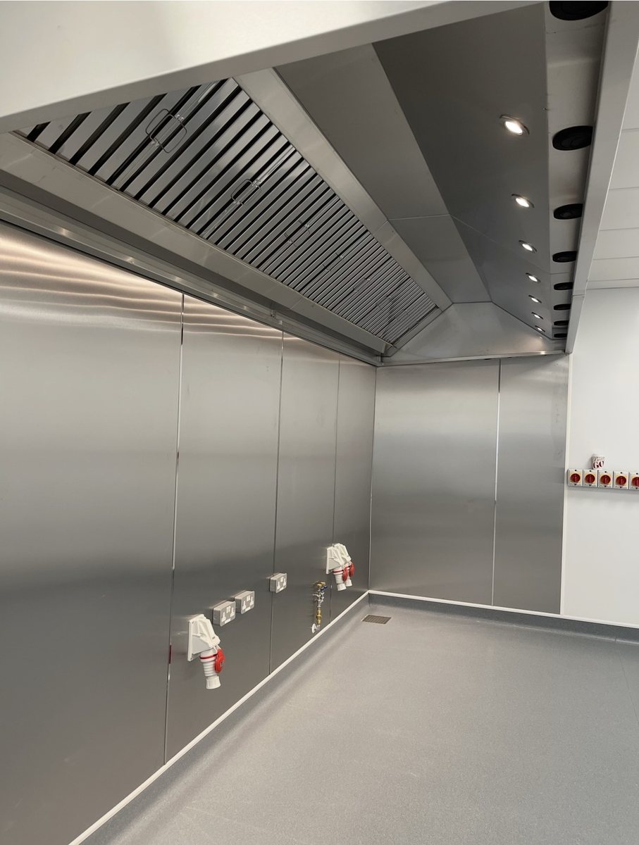 Wall-mounted stainless steel extraction canopy with baffle filters and LED lighting over stainless cladding, Castle Catering Engineers