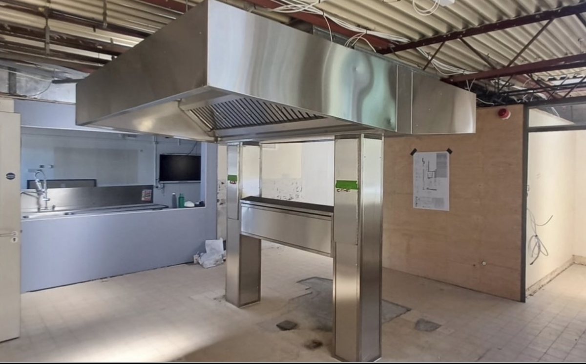 Suspended island extraction canopy on stainless steel support legs during a new-build kitchen fit-out by Castle Catering Engineers