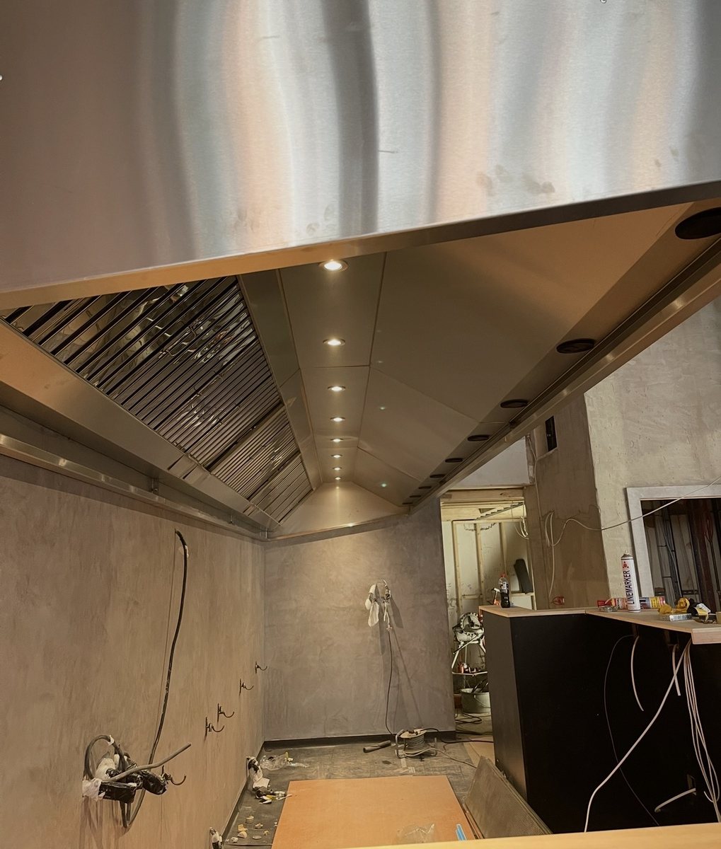 Feature stainless steel extraction canopy with recessed lighting during a commercial kitchen fit-out by Castle Catering Engineers