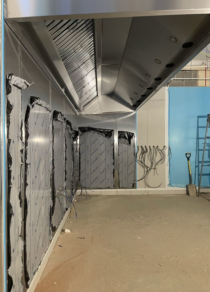 Stainless steel wall cladding and extraction canopy installation in progress on a commercial kitchen project by Castle Catering Engineers
