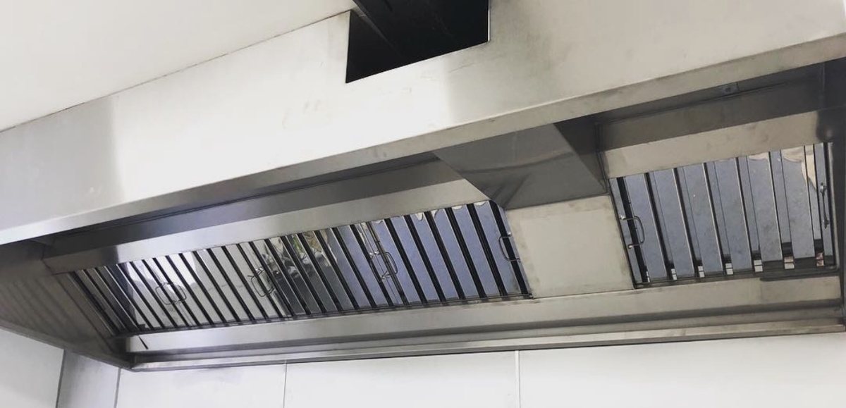 Stainless steel extraction canopy with cleaned baffle grease filters in a finished commercial kitchen, Castle Catering Engineers