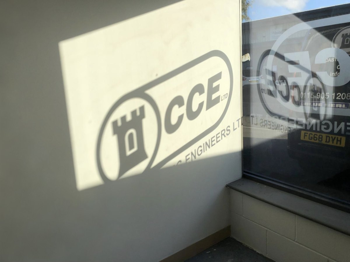 Castle Catering Engineers signage at Unit 8 Pottery Court, Bulwell, with a CCE van reflected in the window