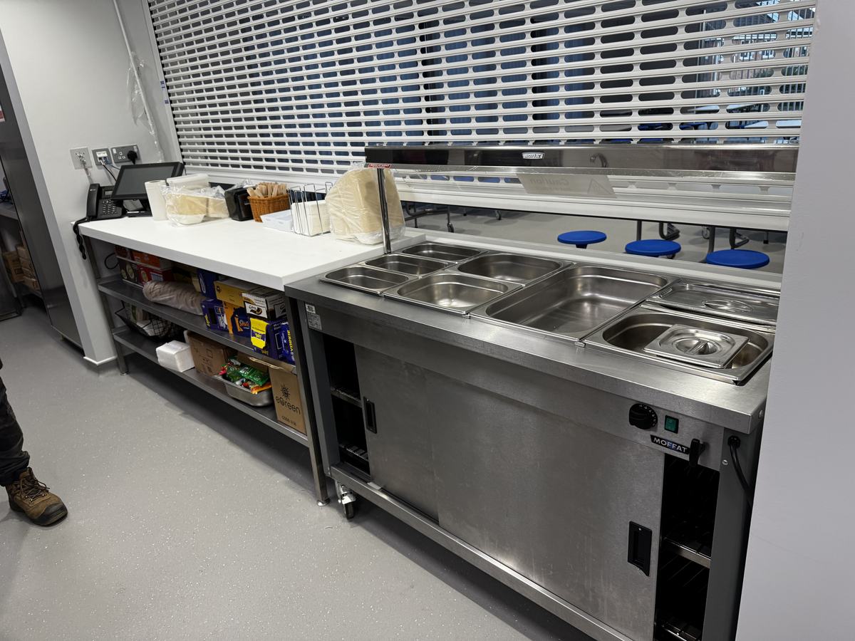 Heanor Gate Spencer Academy — servery interior with Moffat hot bain marie counter and roller shutter open to dining