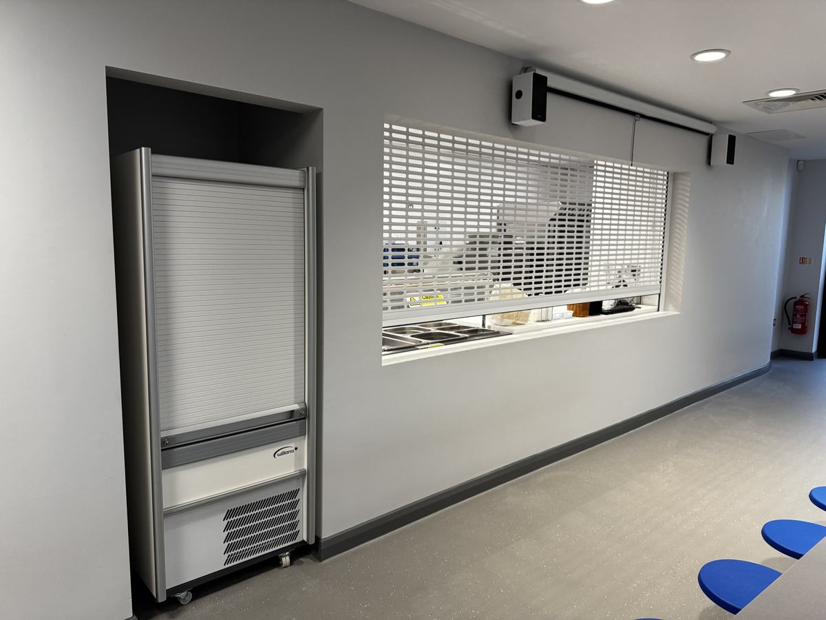 Heanor Gate Spencer Academy — servery from dining area showing Williams upright fridge and roller shutter counter