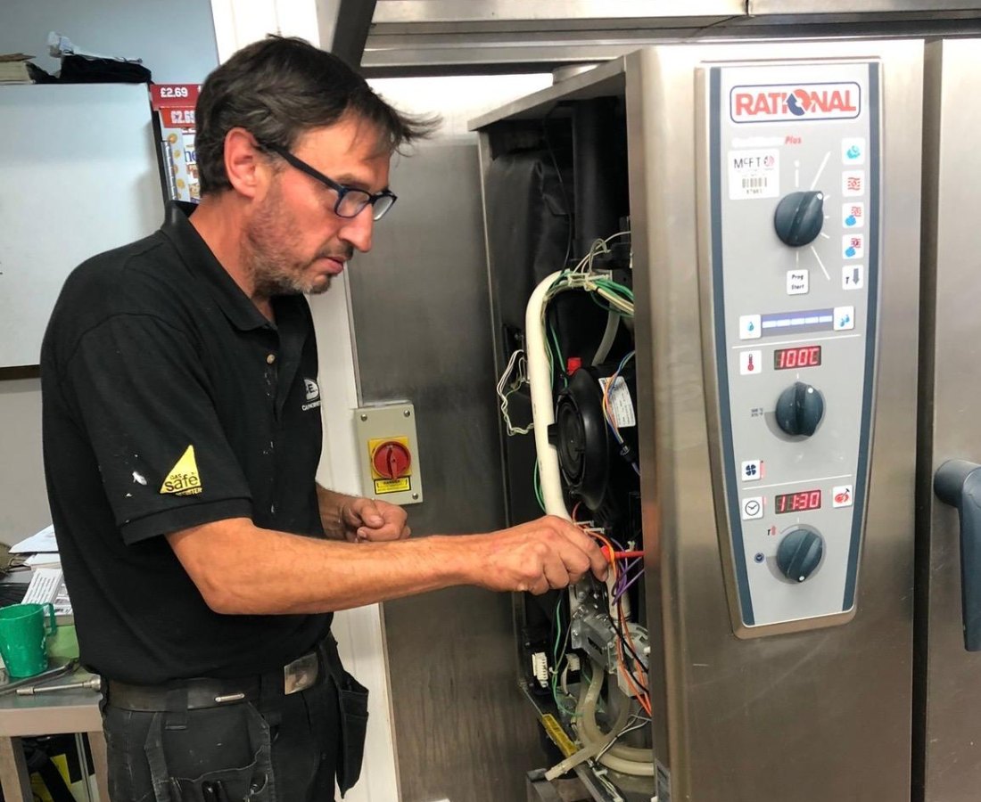CCE Gas Safe engineer servicing a Rational combi oven during a planned maintenance visit