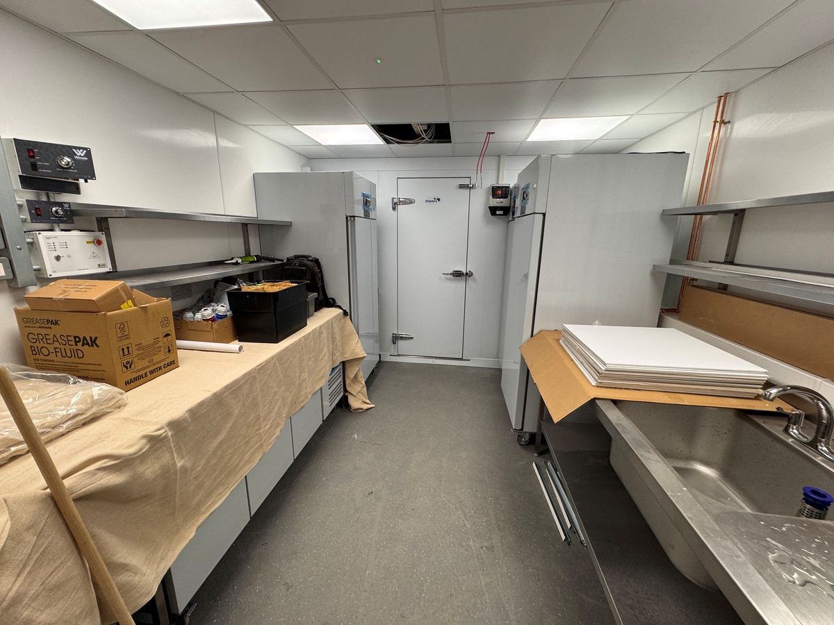 Walk-in chiller room mid-installation — Storers cold room and stainless shelving