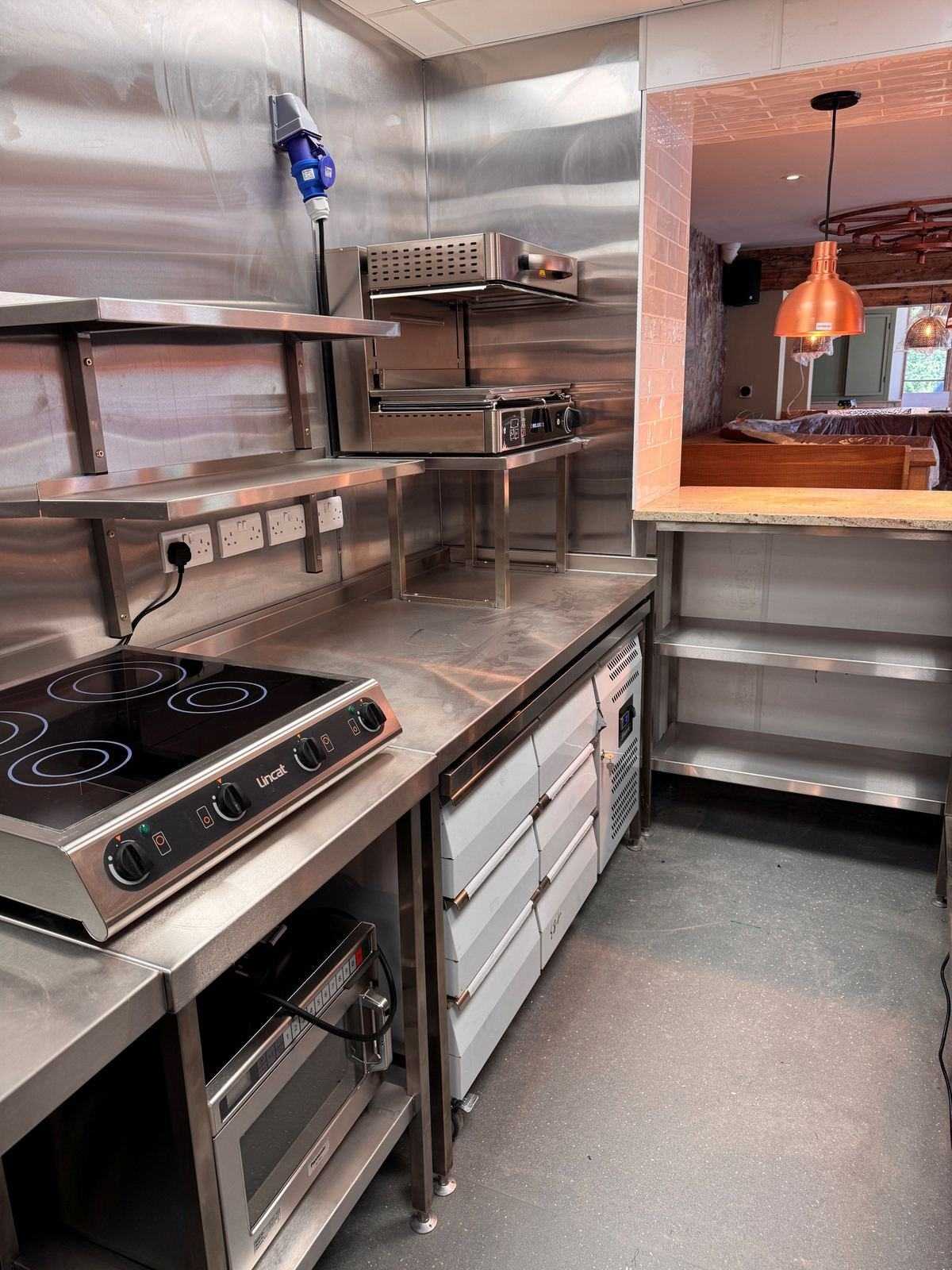 Kitchen — Lincat induction suite, refrigerated prep drawers and marble pass beyond