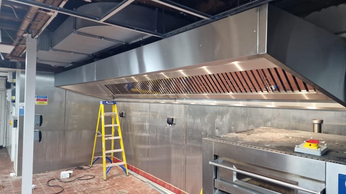 Commercial kitchen canopy installation — CCE bespoke stainless steel extraction canopy being fitted