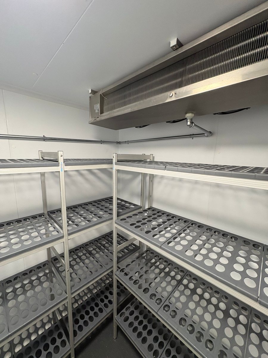 Walk-in cold room interior with aluminium shelving and ceiling-mounted evaporator installed by Castle Catering Engineers