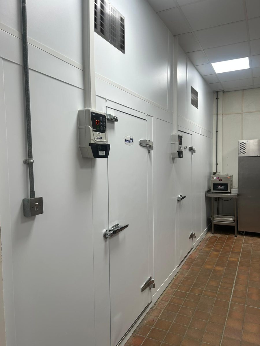 Two Storers cold room doors with digital temperature displays installed in a commercial kitchen corridor